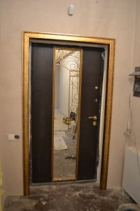 Входная дверь, декорированная интерьерным багетом